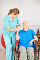 Krankenpflegerin hält Hand einer alten Frau