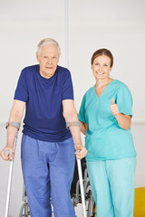 Physiotherapeutin hält Daumen hoch neben Patient