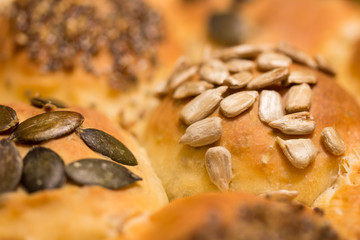 Dinkelbrötchen auf Holzbrett mit Sonnenblumenkernen, Kürbiskernen und Chia-Samen