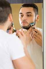Man shaving the beard with a razor