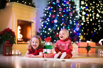 Fototapeta na wymiar Kids playing at fireplace on Christmas eve