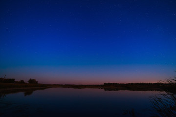 Smooth surface of the lake on a background the starry sky.