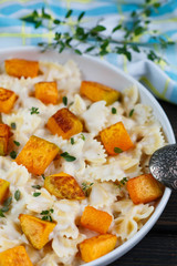 Pasta with pumpkin and thyme with creamy cheese sauce. Farfalle
