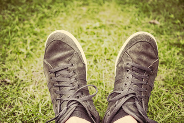 Tennager Feet in sneakers in the green grass