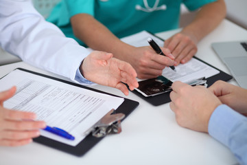 Doctors and patient sitting at the table, arms