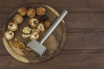 Peeling fresh walnuts, walnut dessert preparation. Walnuts on the kitchen table. Healthy food. Walnut kernels and whole walnuts on table.
