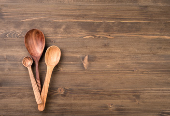 Three wooden spoons at left of wooden table