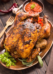 Grilled chicken with vegetables on wooden plate
