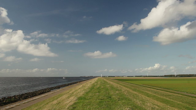 Dike on a polder in the Netherlands. The IJsselmeer on the left (former Zuydersea) and the Noordoostpolder with farmland on the right. The former island of Urk lies on the horizon.