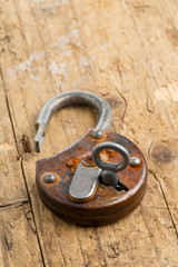 Open antique padlock with key in lock