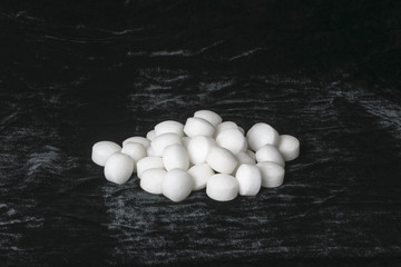 White naphthalene balls on black velvet