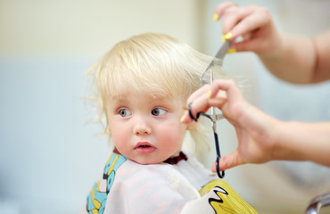 Toddler child getting his first haircut