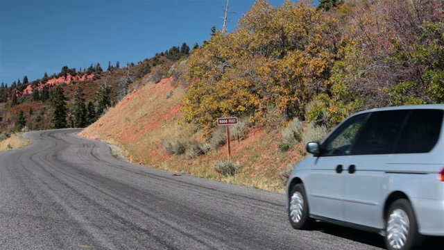Mini van car drives up autumn mountain road HD 9956