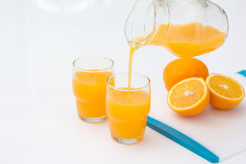 Pouring orange juice into the glass isolated on white