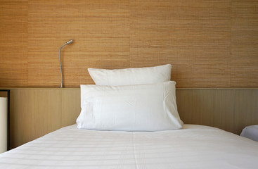 Double white pillow on white bed sheet