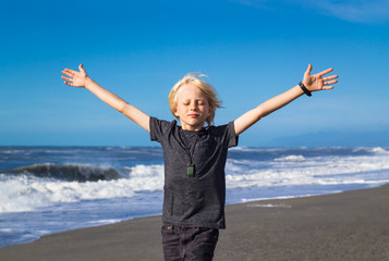 Cute child on beach with arms outstretched freedom concept