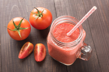 Healthy vegetable. Glass of red tomato juice on wooden table