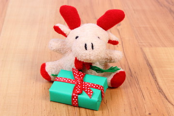 Plush reindeer with gift for Christmas or other celebration