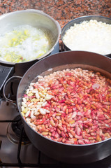 Black cooking pot of white and red beans drained in water with