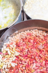 Black cooking pot of white and red beans drained in water with
