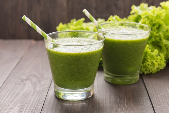 Healthy green vegetables and green fruit smoothie on rustic wood