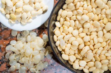 Closeup peeling, before and after bowls with lupini beans