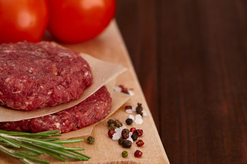 Raw meat beef burger with tomatoes and spices