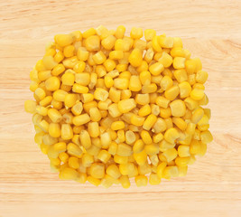 Sweet yellow corn grain over wooden background