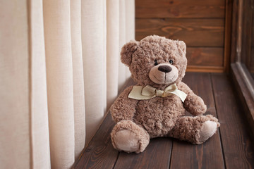 Teddy Bear toy sits on a wooden window sill