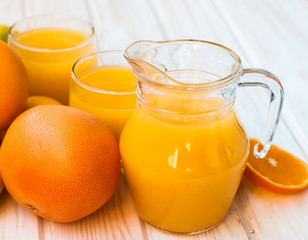 Fototapeta na wymiar Fresh orange juice on wooden table