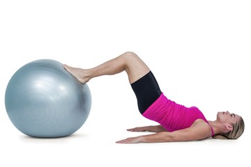 Fototapeta na wymiar Side view of woman exercising with ball