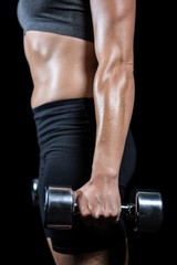 Muscular woman lifting heavy dumbbells