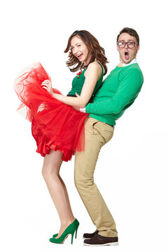 Full body studio portrait of happy couple dancing together. Cute asian teenage girl and nerd young man wearing fifties style clothes posing isolated on white background. Freedom and joy