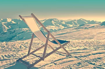 Poster Empty deckchair on the side of a ski slope, vintage process © Delphotostock