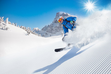 Skier skiing downhill in high mountains