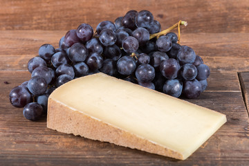 French comté cheese with black grapes