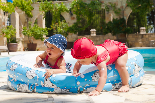 A happy young children is playing outside in a baby swimming pool