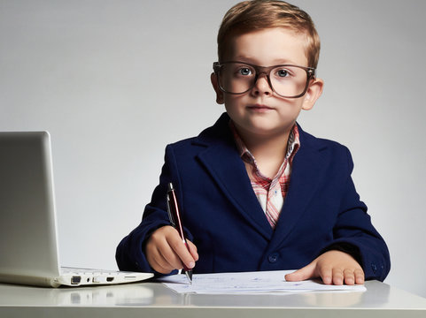 child.Young business boy in office.funny kid in glasses writing pen