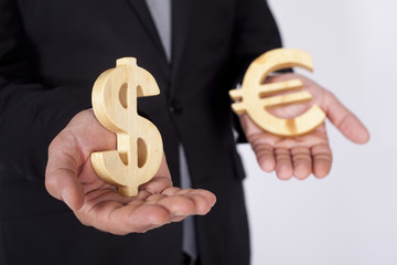 Businessman is holding Dollar and Euro icons