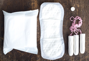Sanitary pads for women with clean white tampons lying on top of