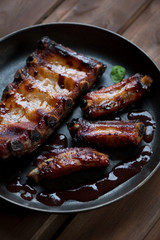 Close-up of baked pork ribs with sauce, studio shot
