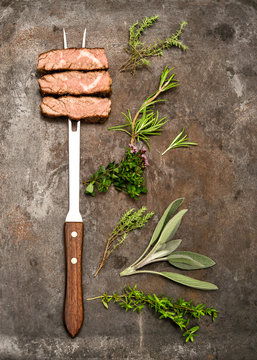 Grilled beef meat herbs spices on metal background. Food