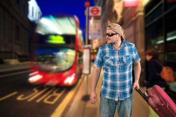 Tourist man in sunglasses standing with suitcase