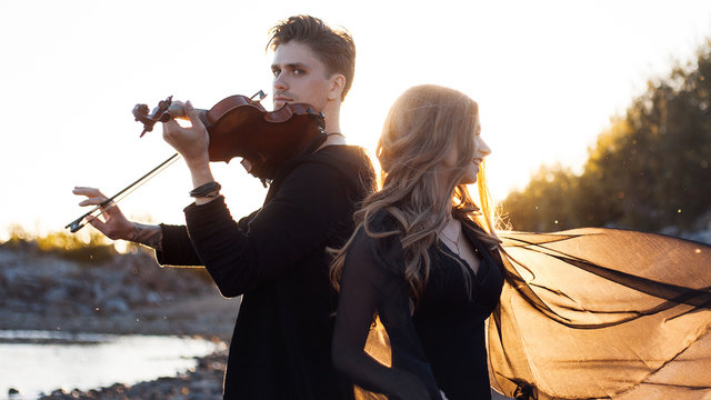 violinist and his Muse,   young man plays on the background of