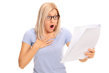 Baffled woman looking at a piece of paper in disbelief