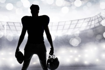American football player silhouette holding ball and helmet