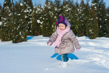 Fototapeta na wymiar Little girl running in the snow in winter, lifestyle, winter holidays