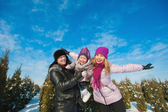 Young beautiful family in bright clothes winter fun jumping and running, snow, lifestyle, winter holidays