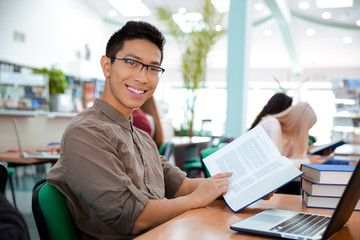 Man sitting at the table with book in university