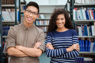 Happy students standing in library
